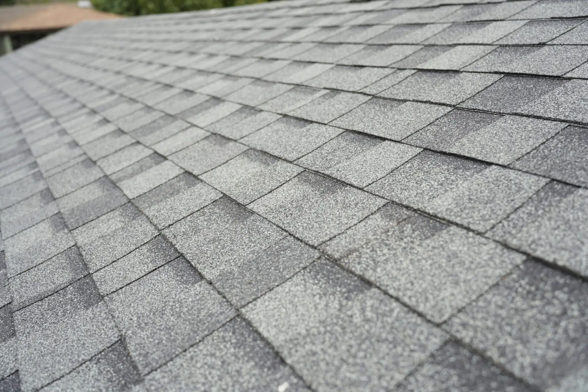 Grey roofing shingles lit by sunlight. ATTYX Roofing