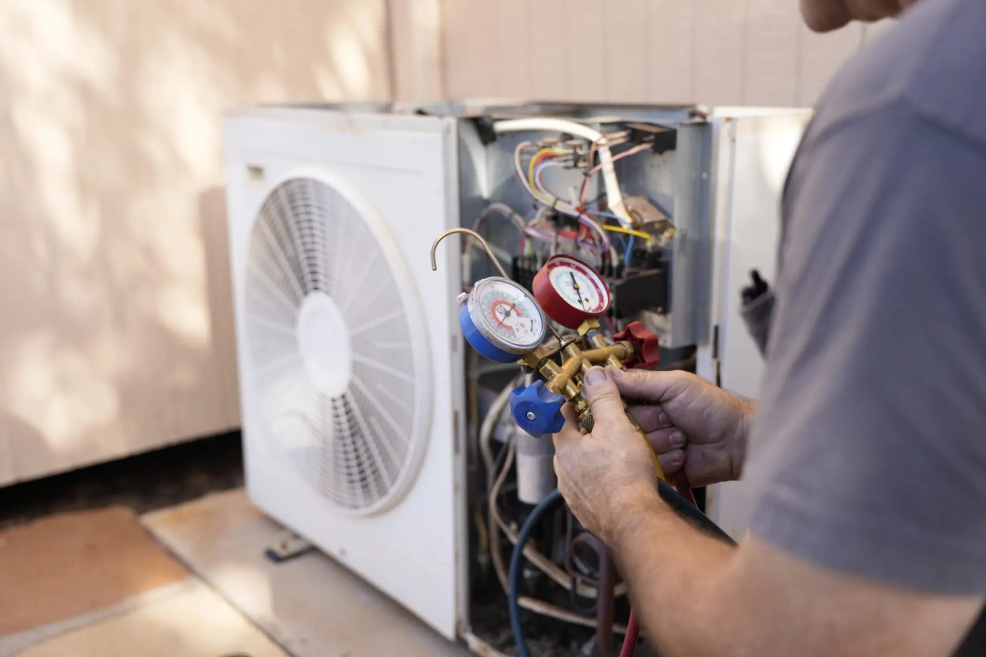 Service technician testing an air conditioning unit. ATTYX HVAC
