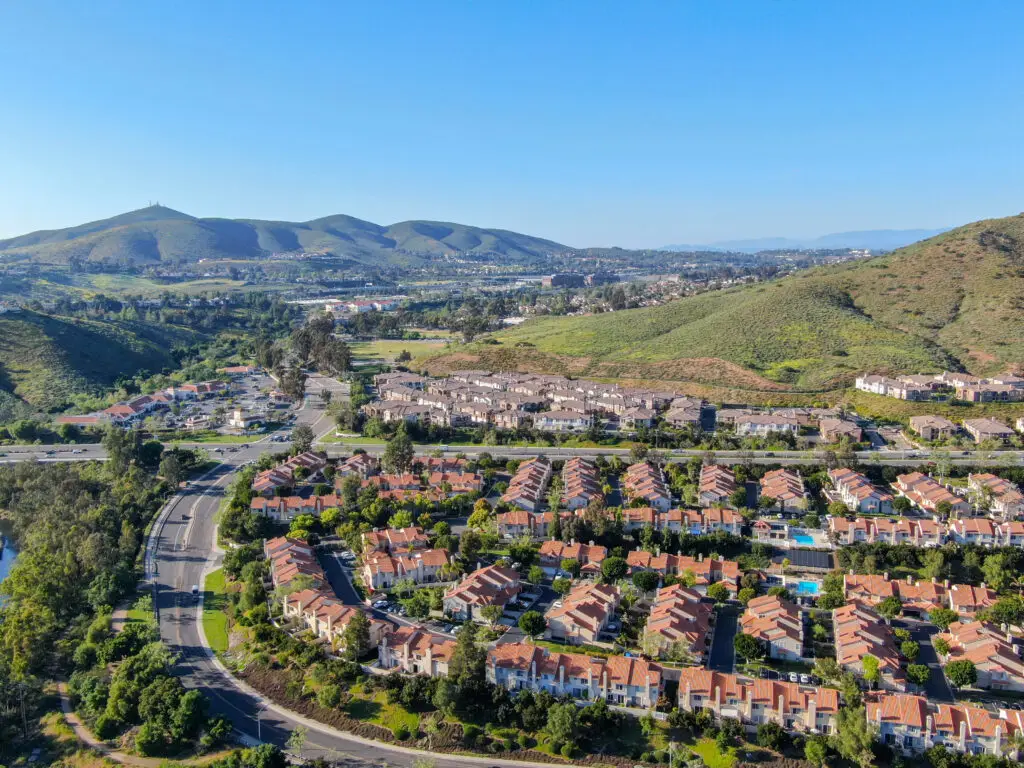 Aerial view suburban neighborhood with identical villas next to each other in the valley. San Diego, California, USA. Aerial view of residential modern subdivision luxury house with swimming pool.