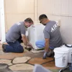 two men working on an hvac system