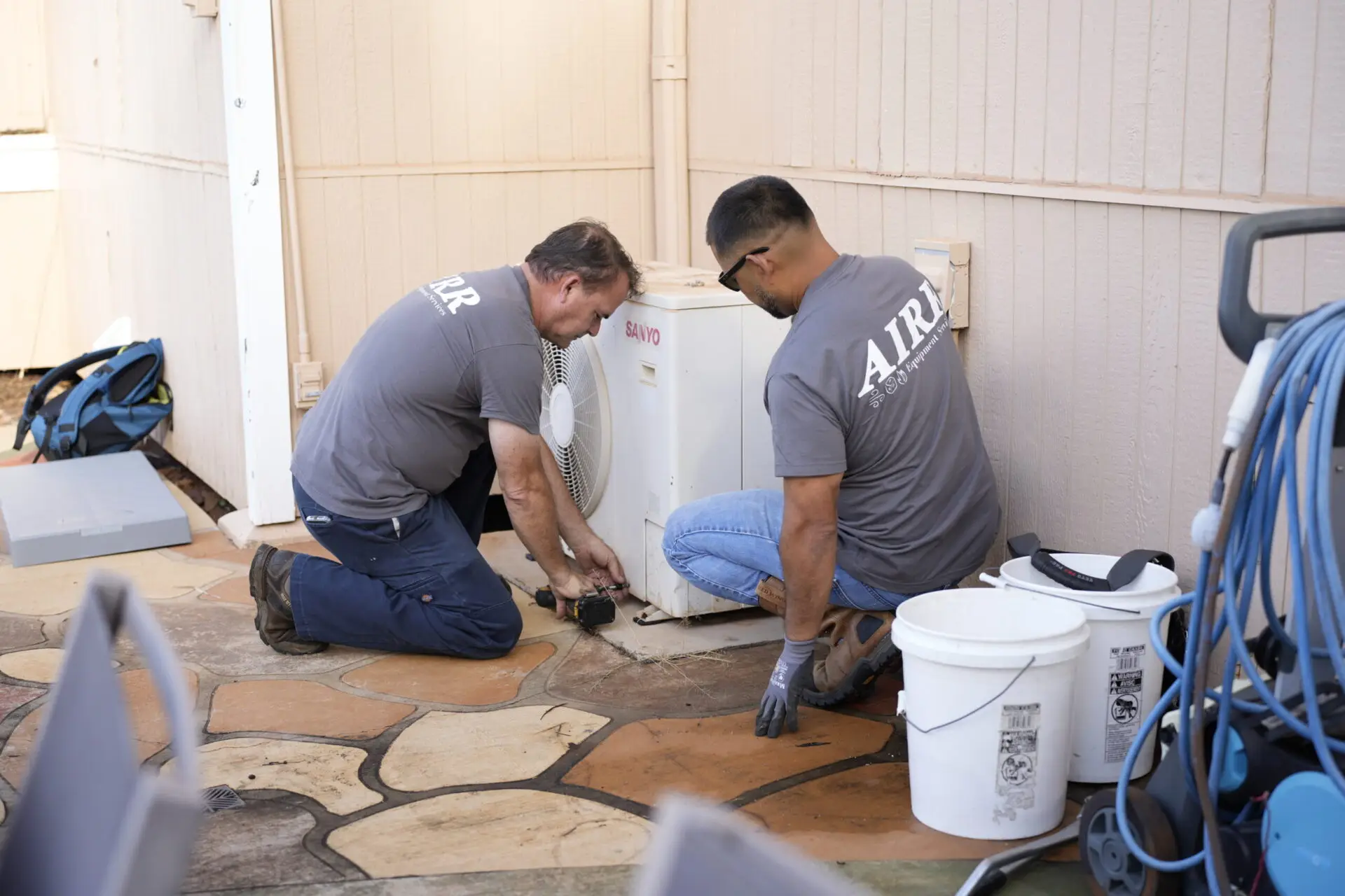 two men working on an hvac system