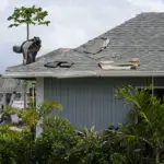 guy on roof fixing shingles